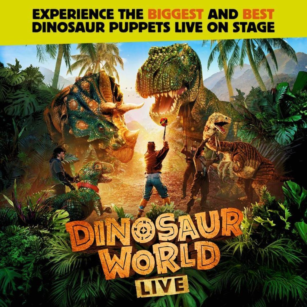 Promotional poster for Dinosaur World Live. In a lush prehistoric jungle, performers interact with large, realistic dinosaur puppets, including a towering Tyrannosaurus rex, a horned Triceratops, and a raptor. Palm trees and dense tropical foliage surround the scene, while dramatic lighting highlights the dinosaurs and performers. The show title, “Dinosaur World Live,””