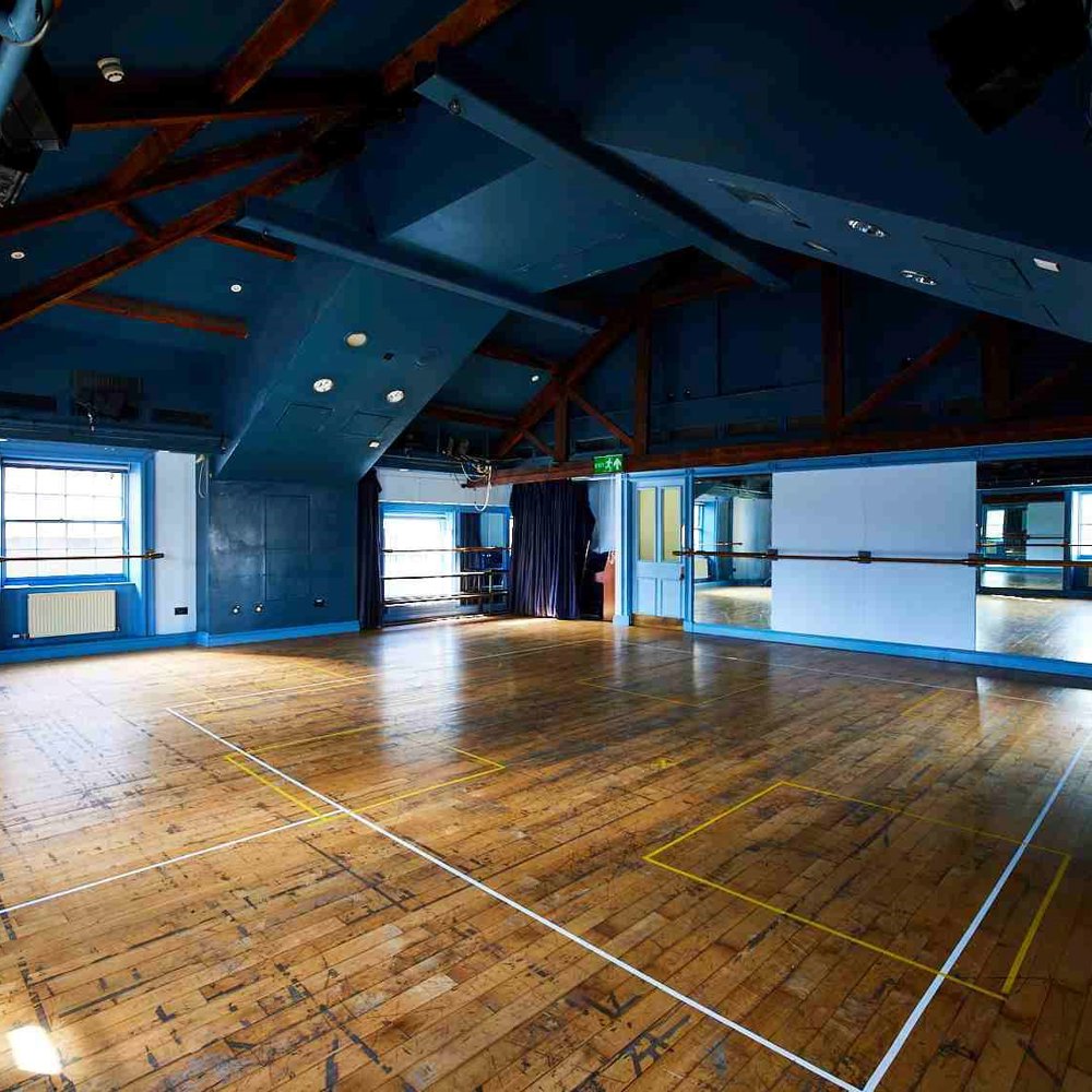 Our Attic Theatre, a large room with blue walls and wooden floor with lots of natural light. An ideal space for rehearsals and workshops.