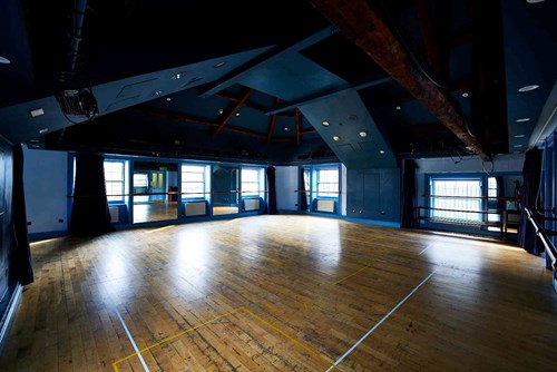 Our Attic Theatre, a large room with blue walls and wooden floor with lots of natural light. An ideal space for rehearsals and workshops.