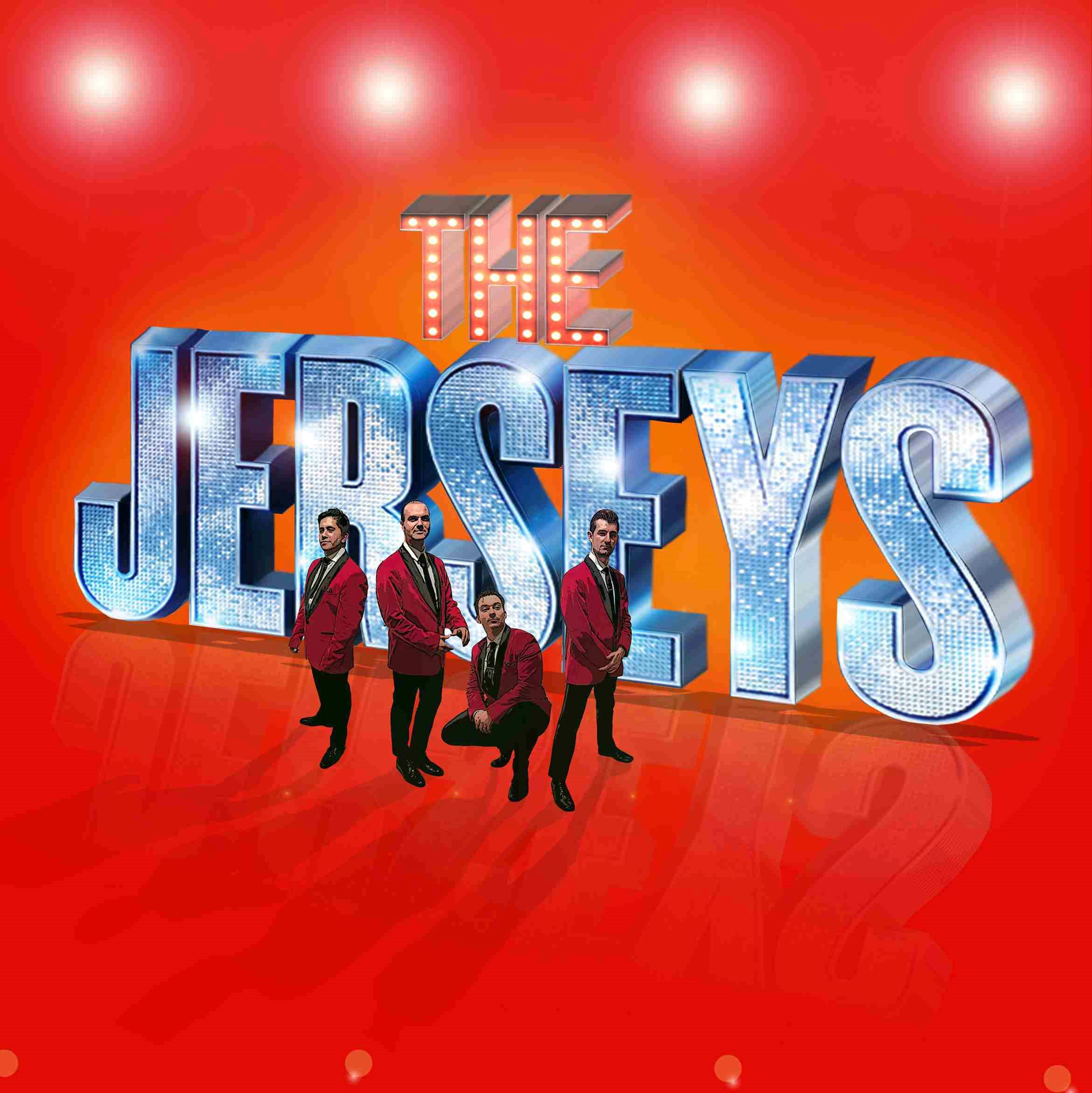 Four men in matching red blazers pose confidently in front of giant sparkling 3D letters spelling “The Jersey Boys” on a bright red and orange background with glowing stage lights overhead.