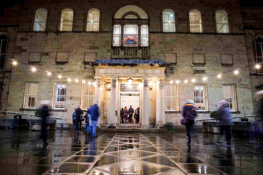 A busy courtyard leading into a building. 
