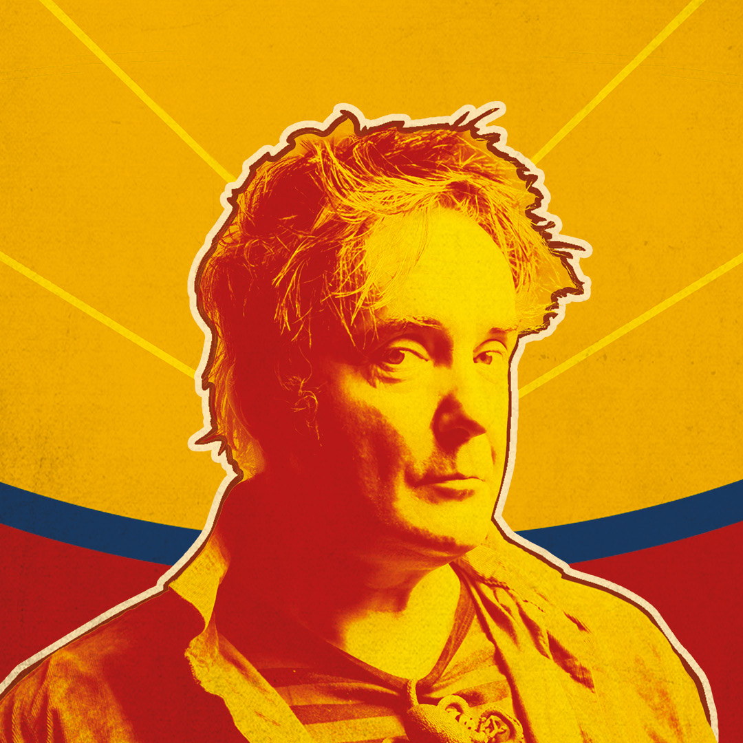 A bold, stylised portrait of a man in warm red and yellow tones, facing slightly to the side. The background features radiating yellow lines with a curved band of blue and red behind him, giving a vibrant, graphic poster-like feel.